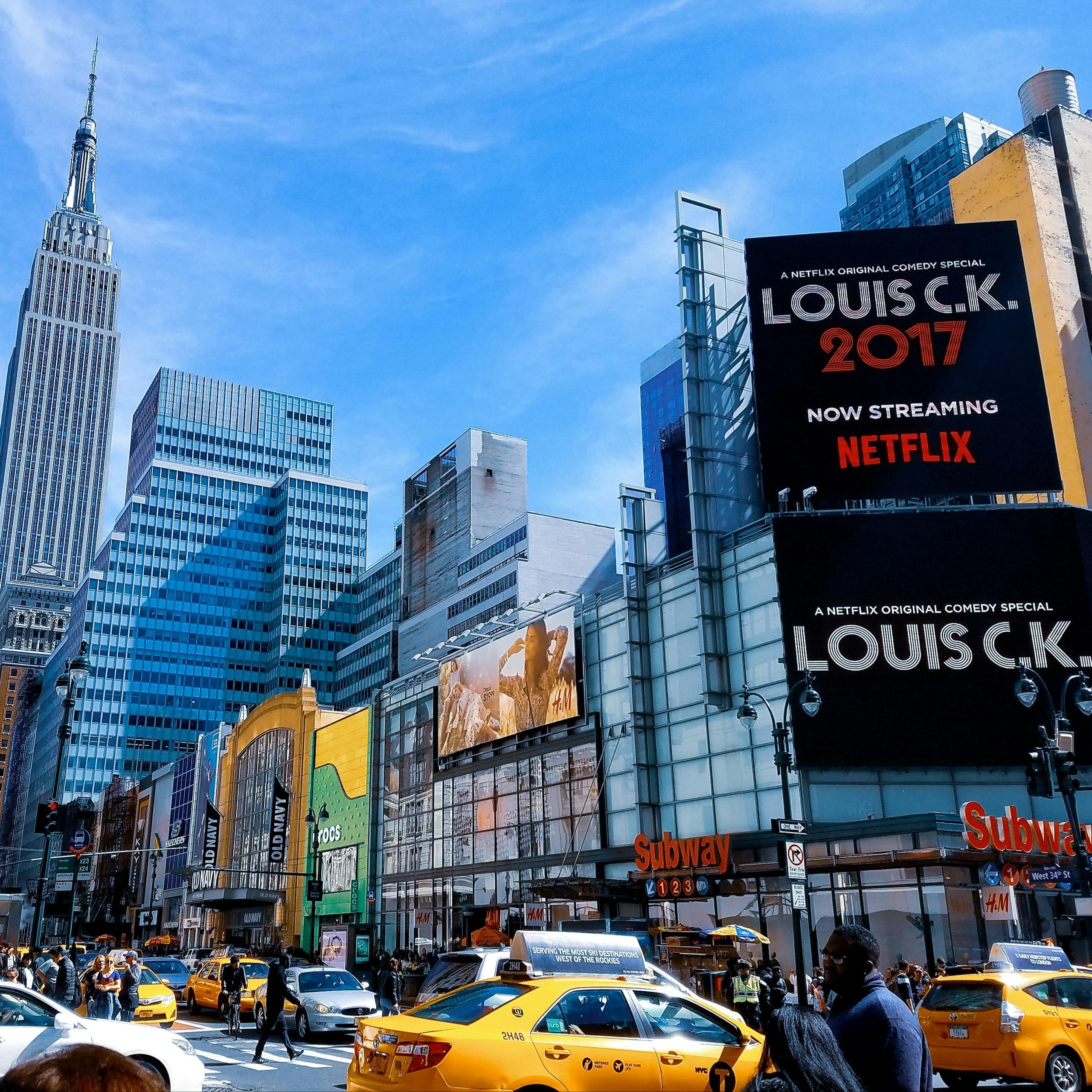A vibrant scene featuring New York City's skyscrapers and taxis under a bright blue sky.